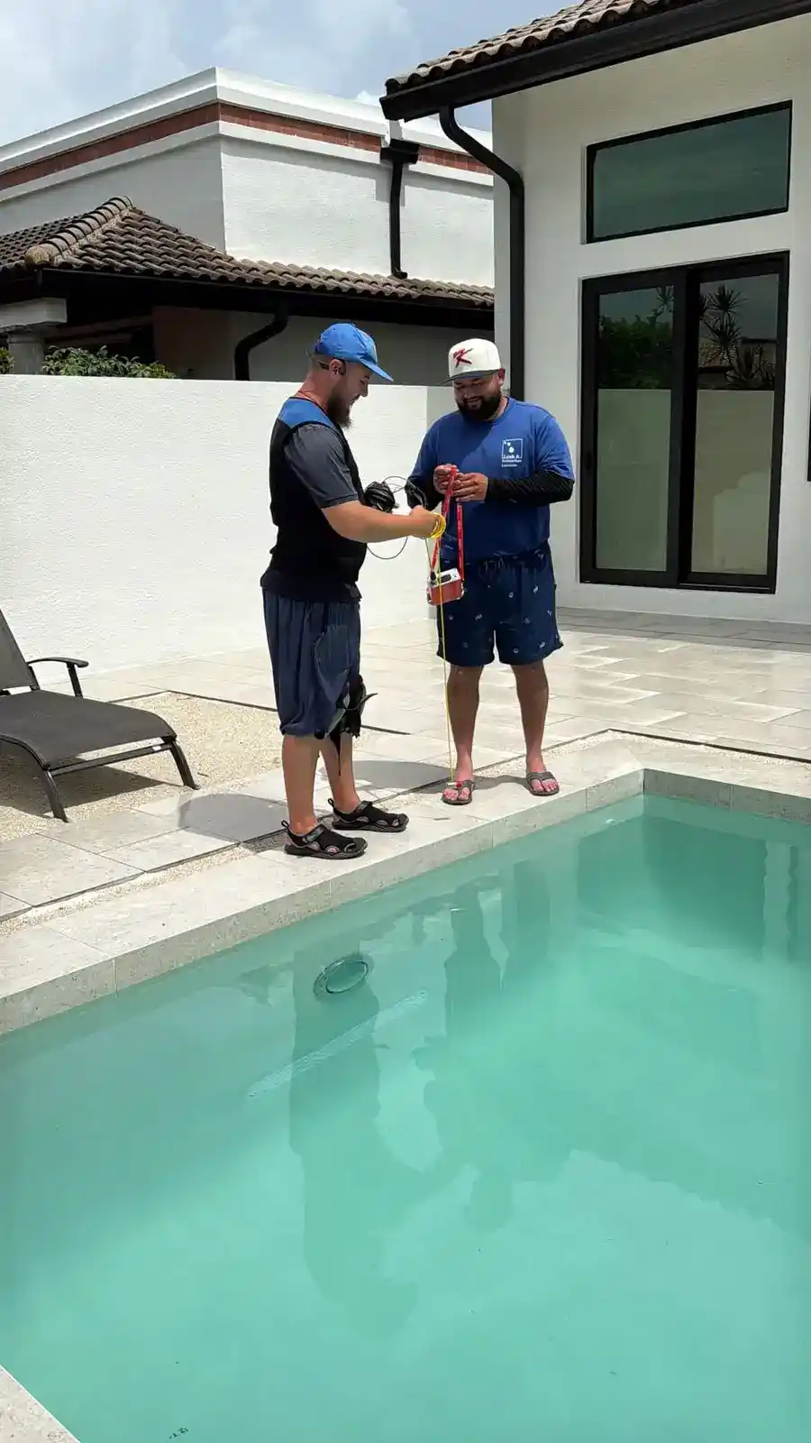 Nathan teaching Franco pool leak detection training in the field