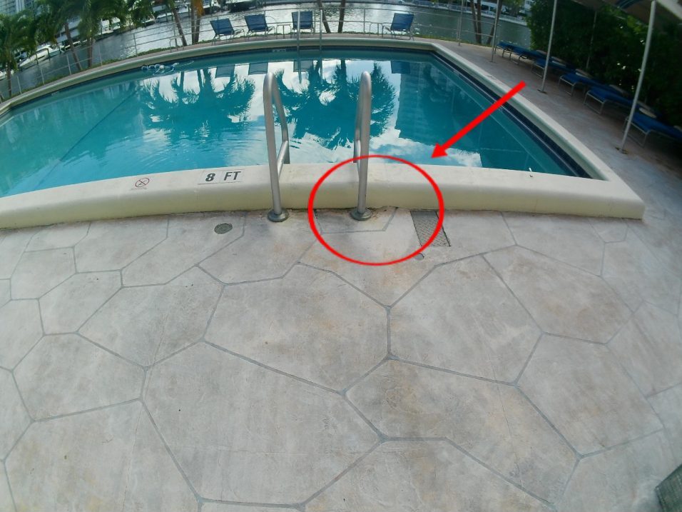 Pool deck marked at the area of the gutter line break near the pool ladder