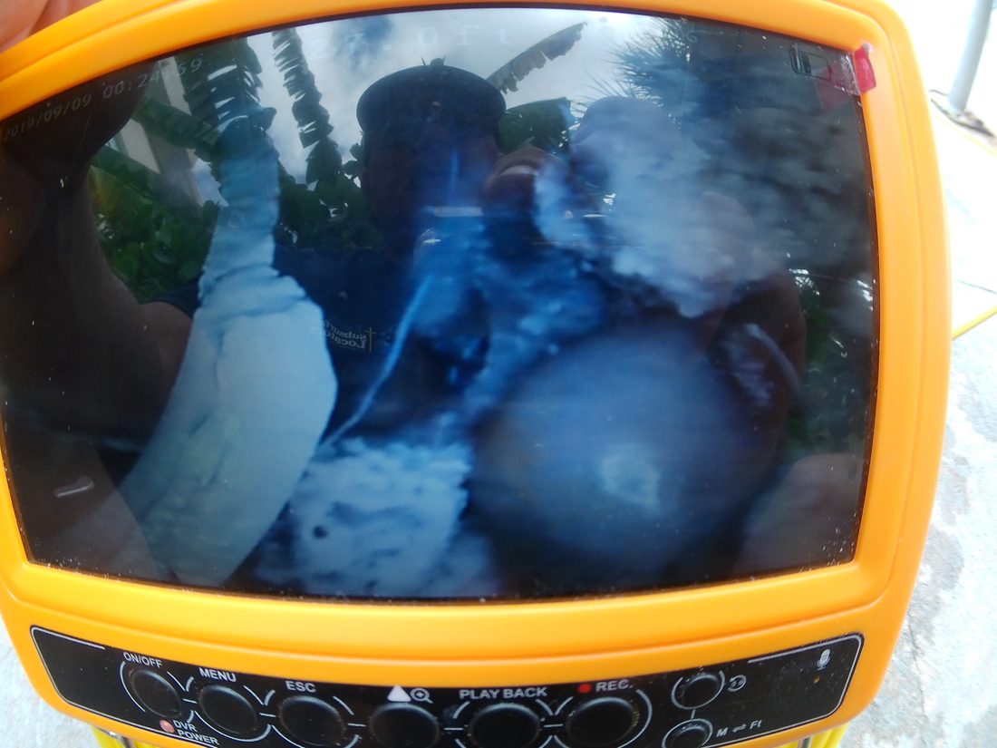Pipe camera monitor showing a separated gutter feeder pipe with dirt inside