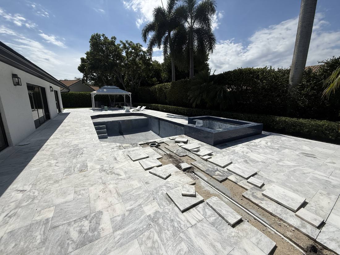 Paver deck lifted at a Delray Beach pool to reach an underground plumbing line, the kind of work that needs a site visit before it can be priced