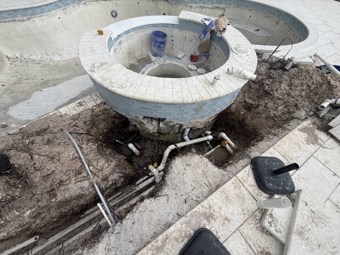 Raised spa excavated at a North Palm Beach home, exposing the plumbing underneath