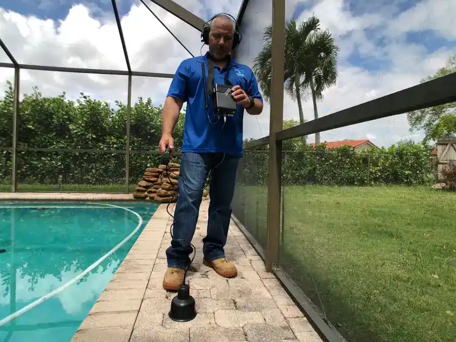 Technician using ground microphone for underground broken pipe locating
